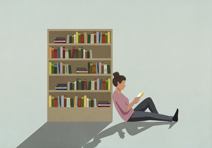 Woman reading book against bookcase