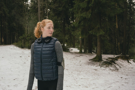 Female runner standing in snowy woods