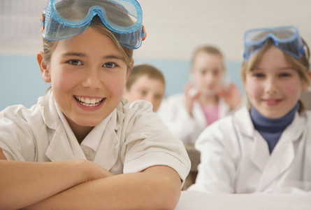 Portrait happy junior high school students in science goggles