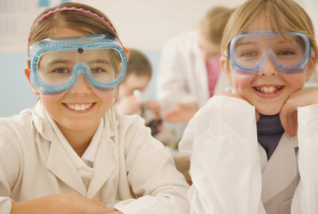 Portrait smiling junior high school girl students in science goggles