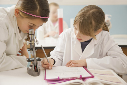 Junior high school girl students conducting scientific experiment