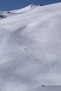 Downhill ski tracks on sunny