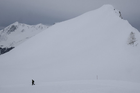 Man snowshoeing below snowy mountain