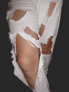 Close up legs of man in ripped white jeans