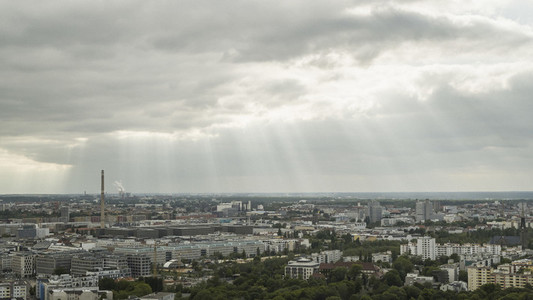 Sunbeams in clouds over Berlin cityscape
