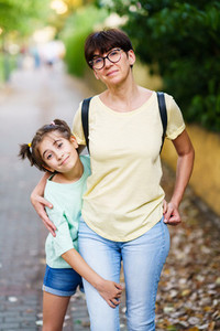 Middle aged mother and daughter standing on the street