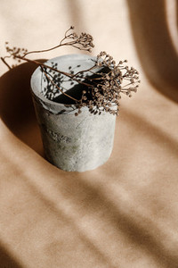 Abstract creative minimal composition with a clay pot and dry grass against kraft paper  Natural and ecological products concept
