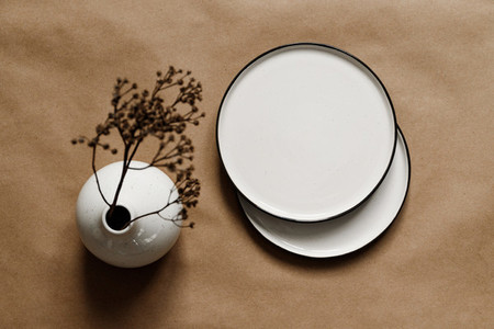 Modern minimalist ceramics plates with a linen cloth over kraft paper