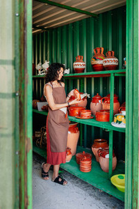 Young clerk checks the stock in a small ceramic shop