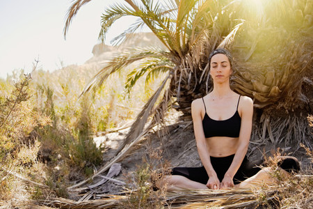 Young active woman practicing yoga in desert on sunny day  health and active life concept