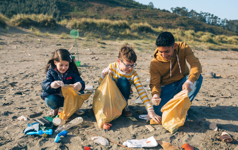 Young volunteers cleaning the beach