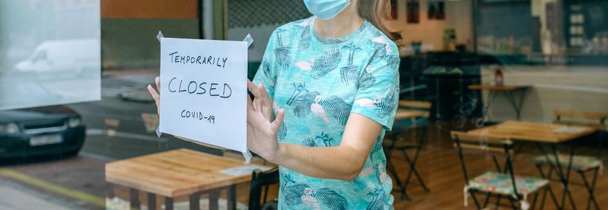 Woman placing coronavirus closure sign
