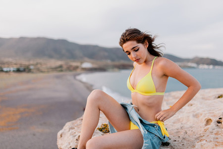 Woman in the beach wearing yellow swimsuit
