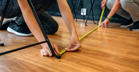 Unrecognizable workers measuring social distance on the floor