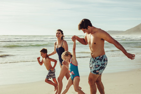 Playful family enjoying playing at beach during vacation
