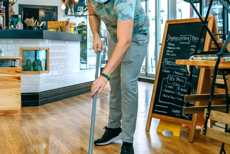 Worker mopping the floor of a coffee shop
