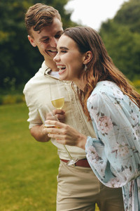 Cheerful couple at the park with champagne