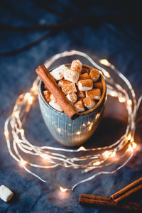 Hot chocolate with marshmallows and cinnamon in blue ceramic cups on a table  The concept of cozy holidays and New Year