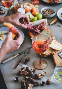 Rose wine cheese charcuterie appetizers and mans hands with food