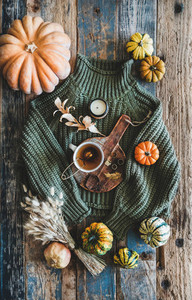 Green sweater and accessories over rustic wooden background  top view