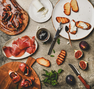 Crostini with prosciutto  cheese and figs over concrete table