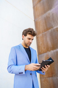 Businessman using a digital tablet near an office building