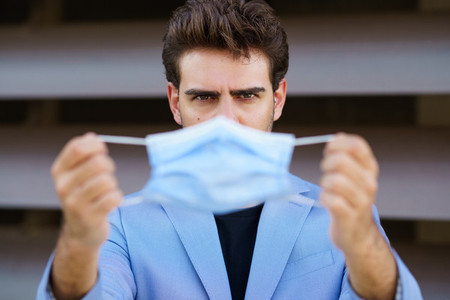 Businessman putting on a surgical mask to protect against the coronavirus