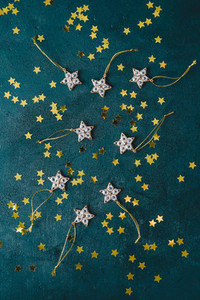 The New Year or Christmas festive flat lay with golden stars over a dark green background