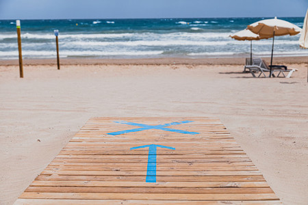 Symbol of an arrow on the wooden walkway in indicating the entrance to the beach