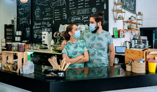 Coffee shop owners posing with masks