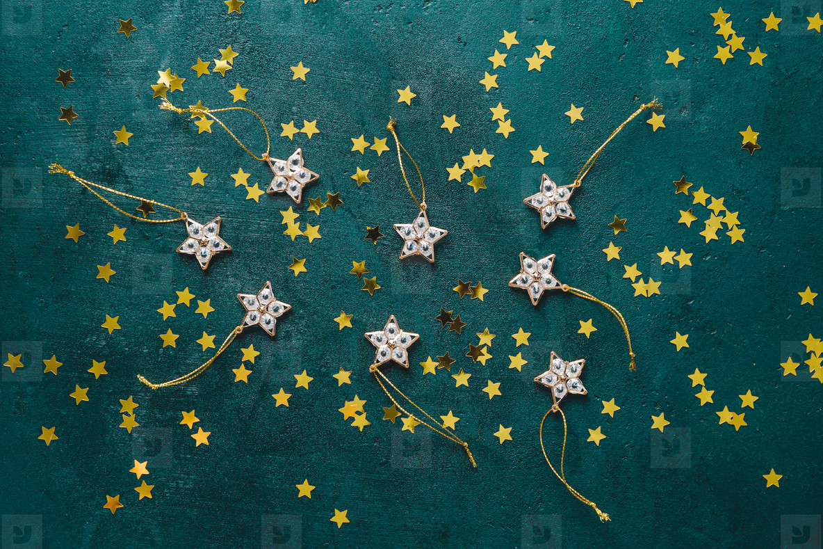 The New Year or Christmas festive flat lay with golden stars over a dark green background Top view copy space