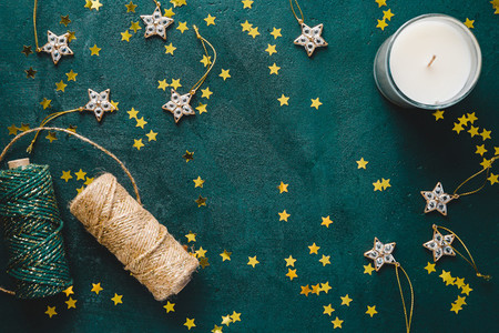 The New Year or Christmas festive flat lay with golden stars over a dark green background  Top view  copy space