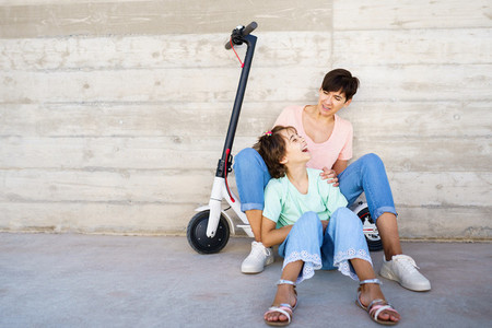 Mother and daughter sitting on an electric scooter