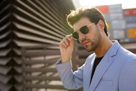Young handsome man wearing sunglasses in urban background