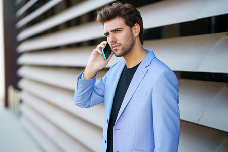 Businessman talking to his smartphone wearing blue suit