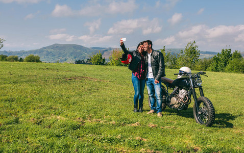 Couple taking a selfie with a motorcycle