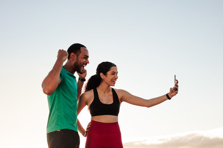 Fitness couple taking selfie outdoors