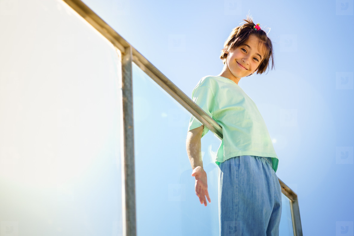 9 year old girl posing happily on a staircase
