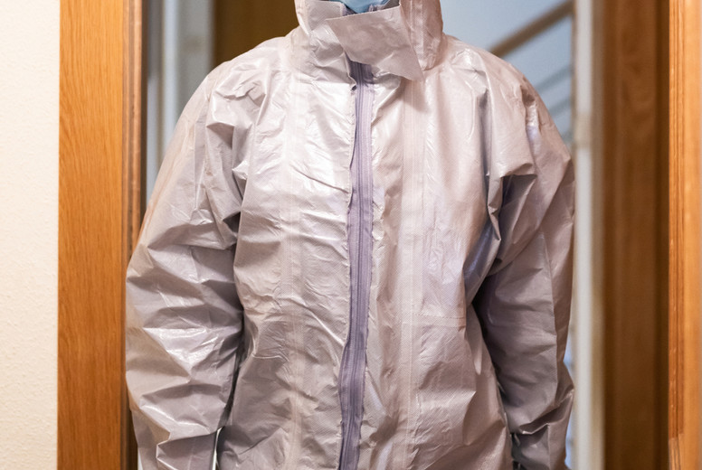 Doctor in PPE Personal Protective Equipment coming into the house