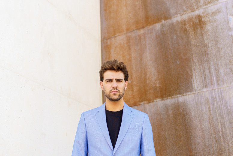 Attractive man wearing suit standing in urban background.