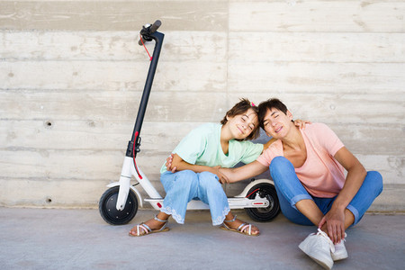 Mother and daughter sitting on an electric scooter