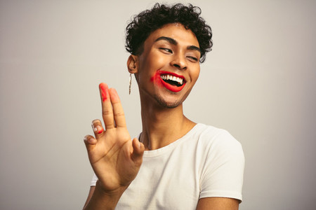 Gay man with smeared lipstick on his fingers