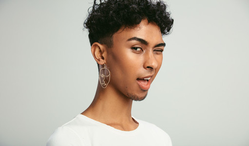 Man with earring winking at camera