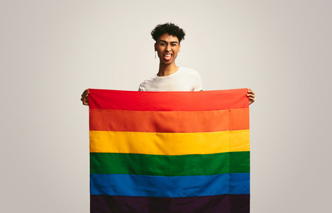 Gay man with pride flag making funny face
