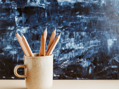 Pencils in a ceramic mug on a table with copy space