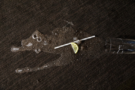 Spilled cocktail  straw and lemon on carpet