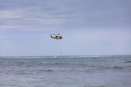 Rescue helicopter training over sunny ocean Adelaide Australia