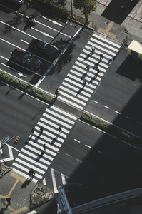 Aerial view pedestrians crossing city street at crosswalk Tokyo Japan