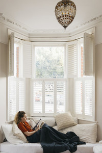 Young woman relaxing on living room in bay window
