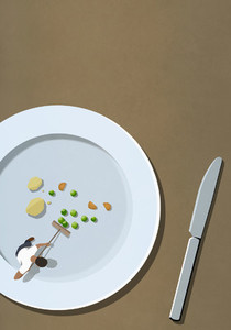Man sweeping up vegetables scraps on large plate